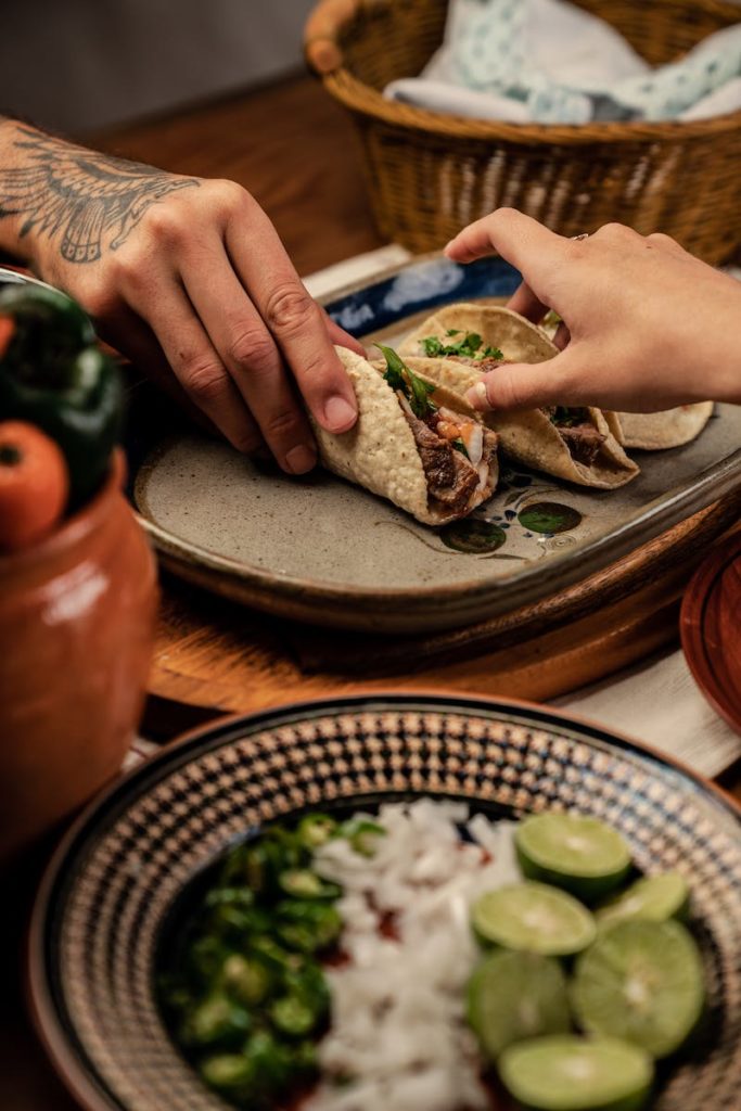 People Holding Tortilla with Beef