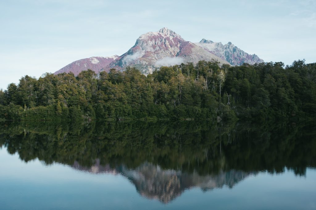 a mountain is reflected in the still water of a lake
